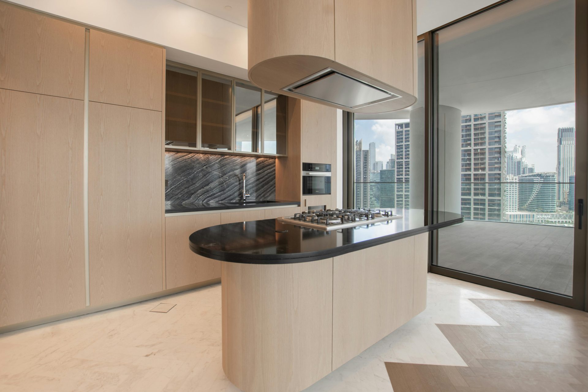 Sleek modern kitchen featuring an island and city skyline view.