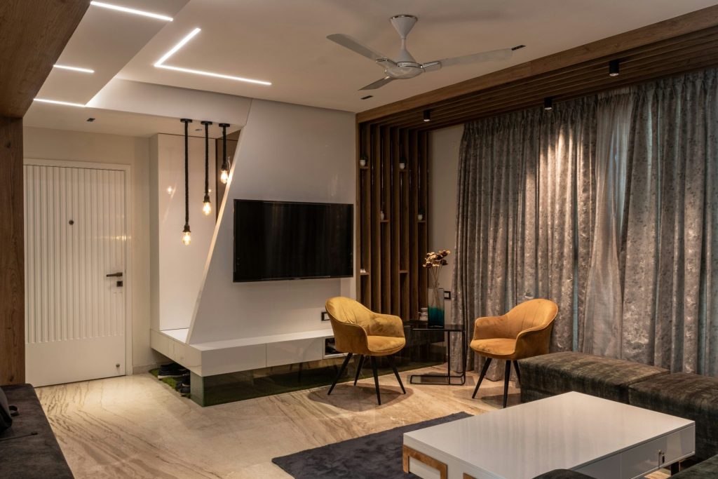 a living room with a tv and chairs